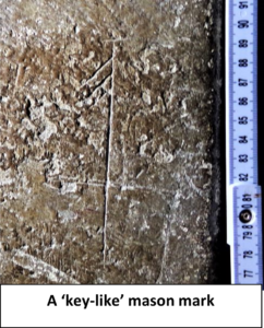 Photo showing mason mark carved into stone. Text reads, " A 'key-like' mason mark".
