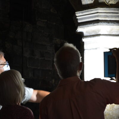 Photo of some people silhouetted against a column inside Greyfriars